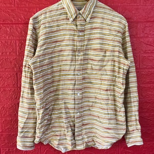 May include: A long-sleeved button-down shirt with a striped pattern in shades of beige, brown, red, and white.