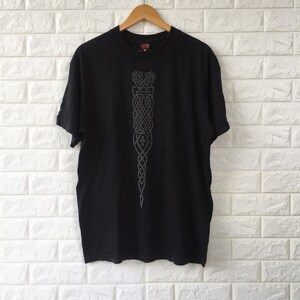 May include: Black t-shirt with a silver Celtic knot design on the front.