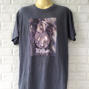May include: Grey t-shirt featuring a graphic print of four horses and a Celtic knot design. The horses are brown and white and the knot is in shades of purple and white.