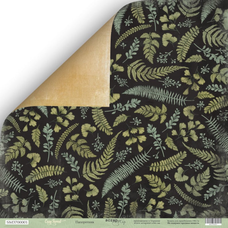 May include: A sheet of scrapbook paper with a dark background and a repeating pattern of green and light green fern and leaf illustrations. The corner is folded over, revealing a tan, textured surface.