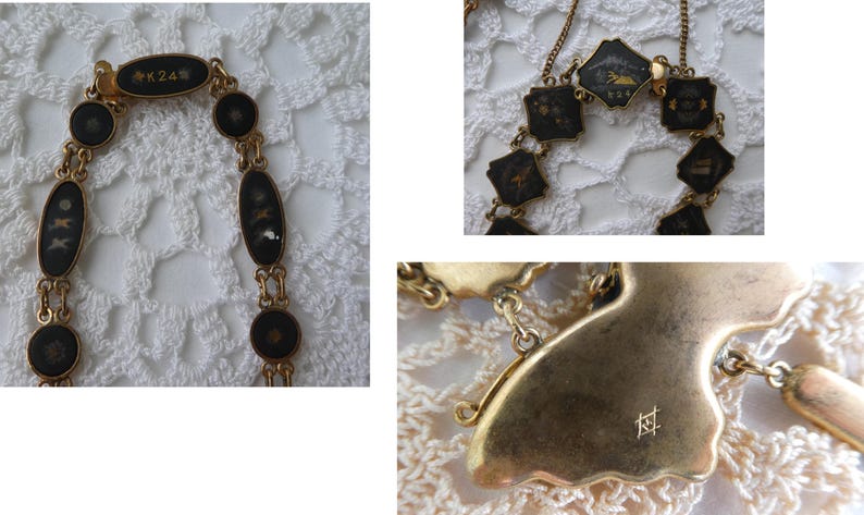 Op de afbeelding: Een gouden ketting met zwarte emaille hangers met ingewikkelde ontwerpen. De ketting heeft een sluiting met de inscriptie "K24".