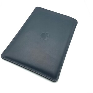 May include: A dark blue leather sleeve with a stitched edge and an embossed Apple logo.
