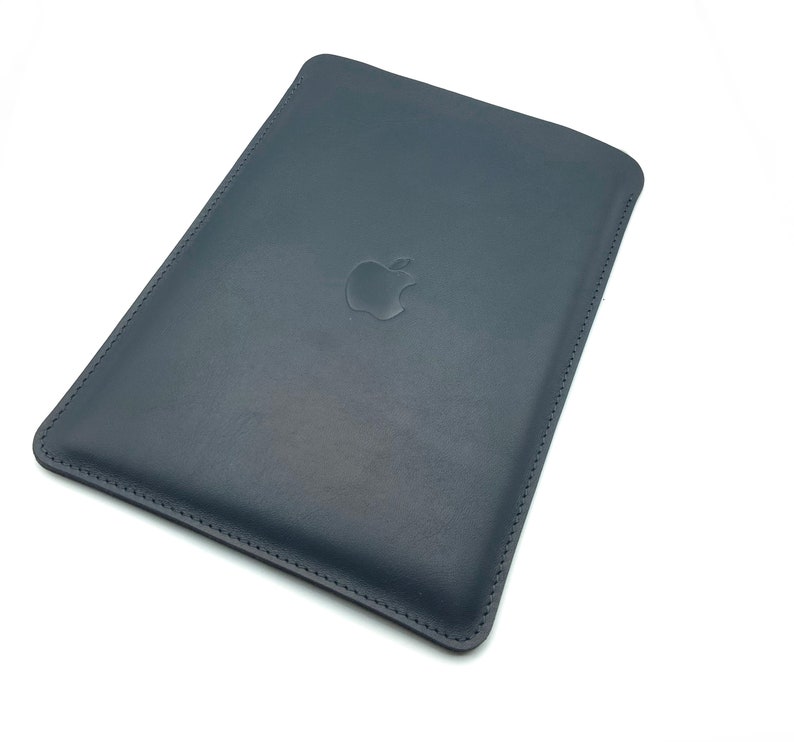 May include: A dark blue leather sleeve with a stitched edge and an embossed Apple logo.