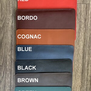 May include: Seven leather swatches in different colors: red, bordo, cognac, blue, black, brown, and green. The swatches are arranged vertically, with the red swatch at the top and the green swatch at the bottom.