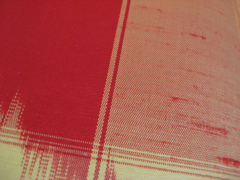 May include: Red and yellow plaid fabric with a woven texture.