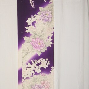 May include: A long, rectangular textile with a deep purple background and floral design. The design features large pink and lavender peonies, white wisteria, and other delicate white flowers and leaves. The fabric has a gradient effect.