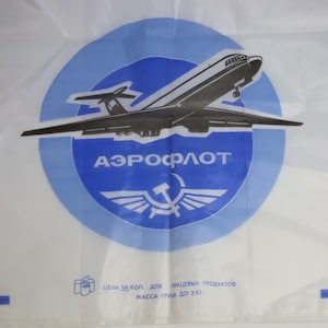 以下が含まれることがあります： 白のプラスチック製の袋に、黒と白の飛行機と「АЭРОФЛОТ」という文字が書かれた青い円が描かれています。円には赤い星と翼も描かれています。袋には「ЦЕНА 35 КОП. ДЛЯ ПИЩЕВЫХ ПРОДУКТОВ. МАССА ГРУЗА ДО 3 КГ.」という文字が書かれています。