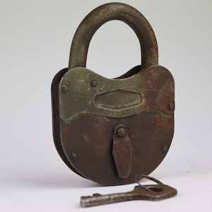 May include: A rusty padlock with a key. The padlock is made of metal and has a brown and silver finish. The key is made of metal and has a brown finish.