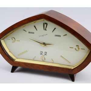 May include: A vintage wooden clock with a white face and gold hands. The clock has a calendar feature and the words "ДРУЖБА" and "СССР" are printed on the face.