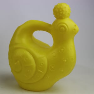 May include: A yellow plastic watering can shaped like a rooster with a textured surface and a small knob on top.