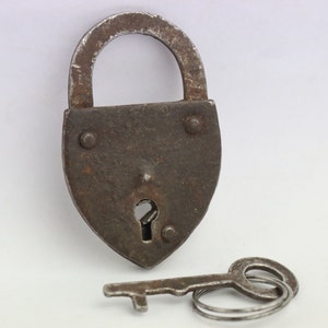 May include: A vintage padlock with a key. The padlock is made of metal and has a heart-shaped design. The key is made of metal and has a simple design.