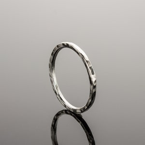 Puede incluir: Un anillo de plata martillado con un acabado liso y pulido.