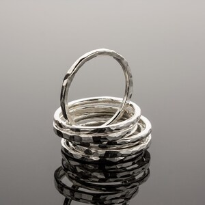 Puede incluir: Una pila de ocho anillos de plata martillados. Los anillos est&aacute;n apilados uno encima del otro, siendo el anillo superior el m&aacute;s grande y el anillo inferior el m&aacute;s peque&ntilde;o.