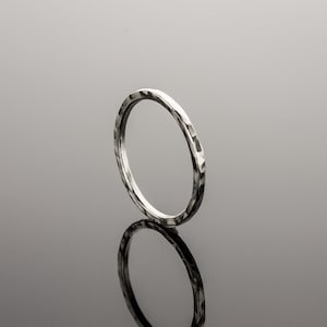 Puede incluir: Un anillo de plata martillado con un acabado liso y pulido.