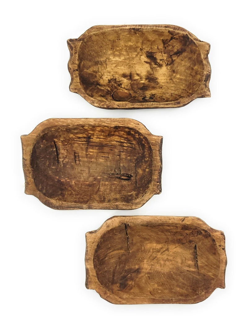 May include: Three rustic wooden dough bowls of varying sizes. The bowls are made of natural wood and have a warm brown color. They are perfect for serving bread, fruit, or other snacks.