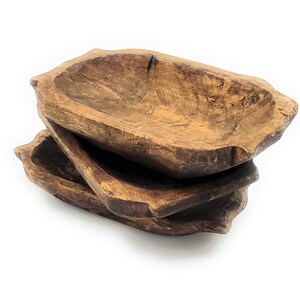 May include: Three wooden bowls stacked on top of each other. The bowls are made of natural wood and have a rustic, hand-crafted look.