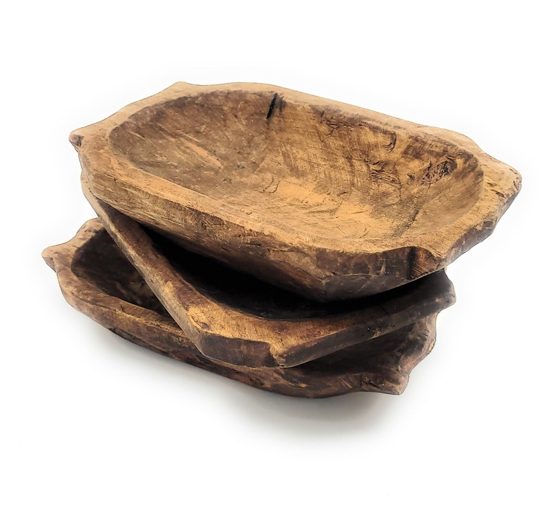 May include: Three wooden bowls stacked on top of each other. The bowls are made of natural wood and have a rustic, hand-crafted look.