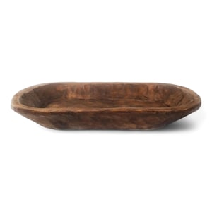 May include: A rustic wooden dough bowl with a natural brown finish. The bowl is oval shaped and has a slightly raised rim.