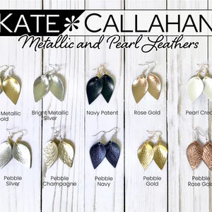 May include: Ten pairs of leather earrings in various colors and finishes, including gold, silver, rose gold, navy, cream, and champagne. The earrings are shaped like teardrops and are arranged in two rows of five. The text "KATE CALLAHAN Metallic and Pearl Leathers" is at the top of the image.