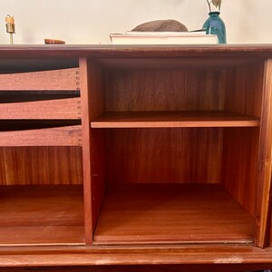 May include: A wooden cabinet with two drawers and a shelf. The cabinet has a light brown finish and is made of solid wood.