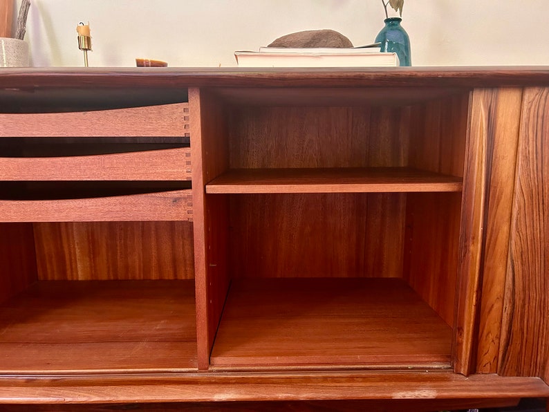May include: A wooden cabinet with two drawers and a shelf. The cabinet has a light brown finish and is made of solid wood.
