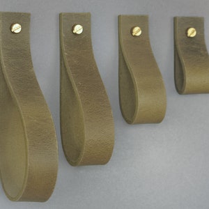 May include: Four olive green leather cabinet pulls with a brass screw in the centre of each pull.