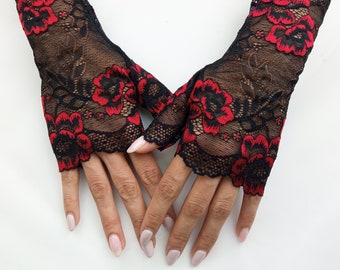 May include: A pair of black fingerless gloves with red floral lace detailing.
