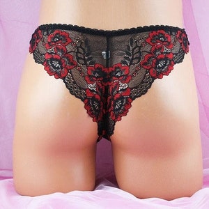 May include: Black lace underwear with red floral embroidery. The underwear has a low rise and a thong back.