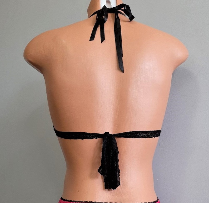May include: Black lace halter top with adjustable straps and a tie back.