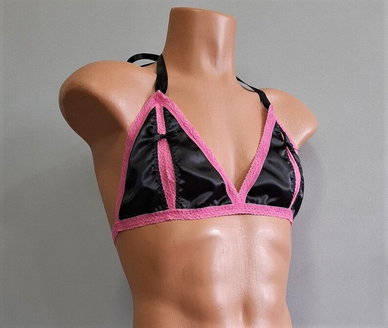 May include: A black satin bralette with pink lace trim and a bow detail. The bralette has adjustable straps and a hook and eye closure.