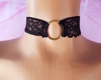 May include: Black lace choker with a gold metal ring.