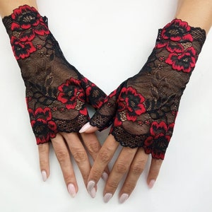 May include: A pair of black fingerless gloves with red floral lace detailing.