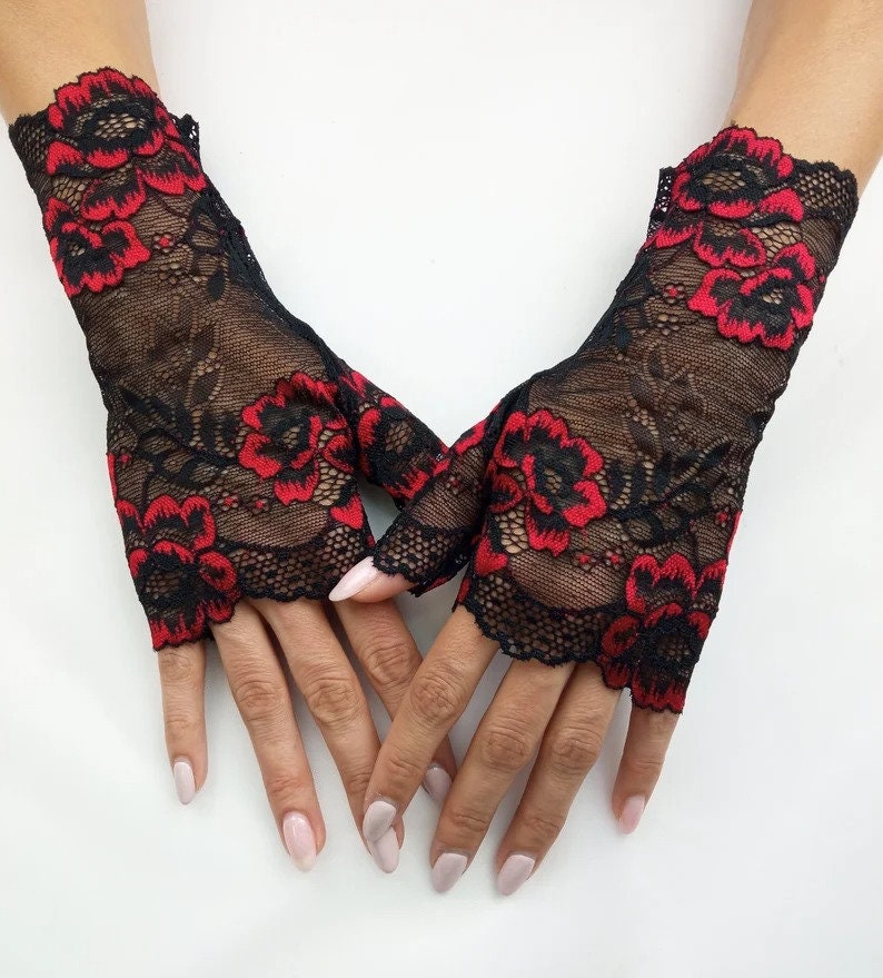 May include: A pair of black fingerless gloves with red floral lace detailing.