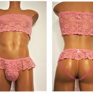 May include: Pink lace lingerie set with a strapless bra and a ruffled panty. The set is made of delicate lace and has a feminine design.