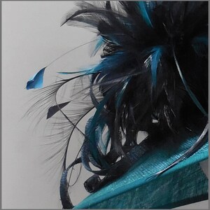 May include: A teal blue hat with a black and teal feather embellishment.