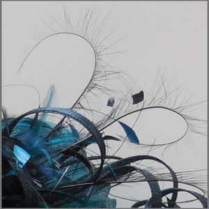 May include: A teal blue and black feather fascinator with a delicate, wispy design. The feathers are arranged in a circular pattern, creating a soft and elegant look.