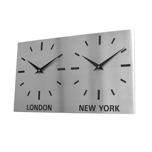 Può includere: Un orologio da parete rettangolare in metallo spazzolato con due quadranti. Ogni quadrante ha lancette nere e indicatori neri. Le parole "LONDON" e "NEW YORK" sono stampate sotto.