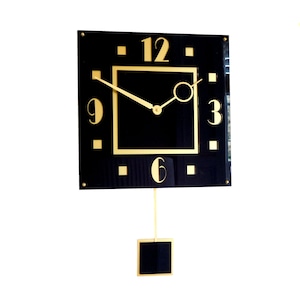 Peut inclure: Une horloge carrée noire avec des accents dorés et des chiffres romains. L'horloge a un pendule et une aiguille des heures et des minutes dorée.