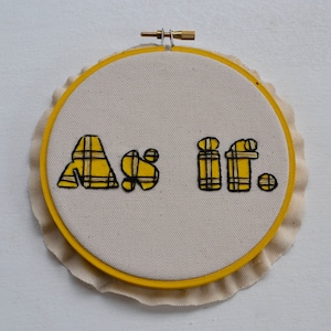 May include: A yellow and black embroidered hoop art piece with the text "As if."