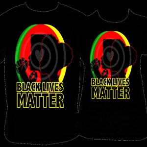 Pu&ograve; includere: T-shirt nere con un design grafico raffigurante la silhouette di una persona con il pugno alzato, su cerchi concentrici rossi, verdi e gialli. Il testo "BLACK LIVES MATTER" &egrave; visualizzato in giallo.