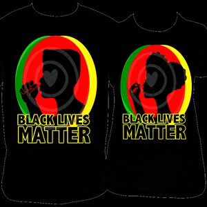 Pu&ograve; includere: Magliette nere con la scritta "BLACK LIVES MATTER" in lettere gialle. Ogni maglietta presenta la silhouette di una persona con il pugno alzato all'interno di un cerchio rosso, verde e giallo.