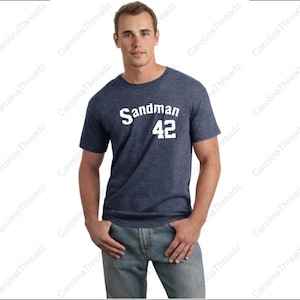 May include: A navy blue t-shirt with a white graphic that says "Sandman 42".