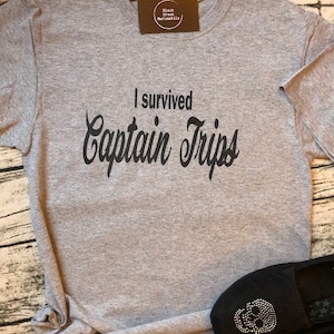 May include: Gray t-shirt with black text that reads "I survived Captain Trips".