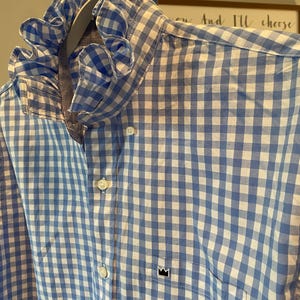 May include: A white ceramic mug with a black handle and the text "But First, Coffee" in a black, handwritten-style font. The mug is on a white surface.