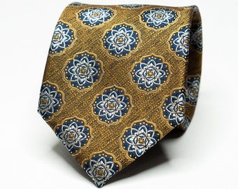 May include: A gold tie with a blue and white floral pattern.