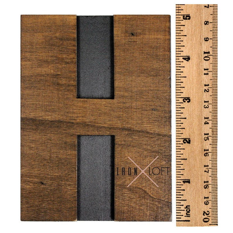 May include: A wooden letter H with a black metal inlay. The letter is approximately 6 inches tall and is made of reclaimed wood. The letter is a rustic and industrial style.