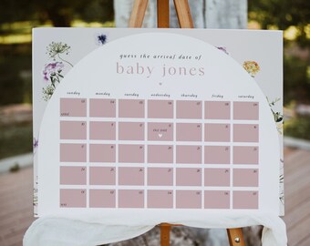 May include: A white sign with a floral design and a calendar for guessing the arrival date of baby Jones. The due date is marked with a heart.