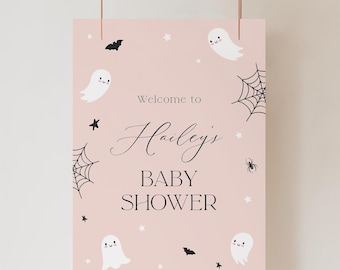 Może przedstawiać: Różowy znak baby shower z napisem "Welcome to Hailey's BABY SHOWER". Znak jest ozdobiony białymi duchami, czarnymi nietoperzami, pająkami, gwiazdami i pajęczynami.