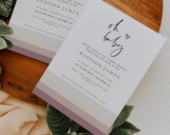 May include: Two white baby shower invitations with a pink and purple ombre background. The invitations feature the text "oh baby" in black script with a heart. The text "please join us for a baby shower honoring the mom-to-be" is in black text. The name "MADISON JAMES" is in pink text. The invitations also include the date, time, and location of the baby shower.