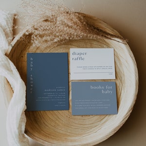 May include: Two blue cards with white text on a wooden tray. The top card says "diaper raffle" and the bottom card says "books for baby".